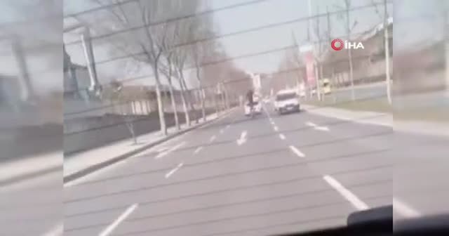 Trafikte motosiklet üzerinde ayağa kalkan sürücü kamerada