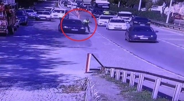 Kendisini durdurmak isteyen trafik polisini otomobiliyle metrelerce sürükledi