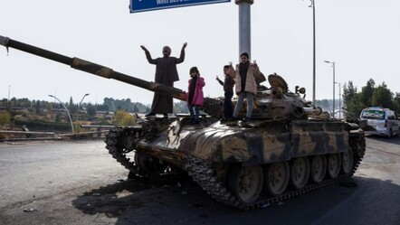 Suriyeliler, Esad rejiminden kalan tankların üzerinde zafer kutlaması yaptı - dunya